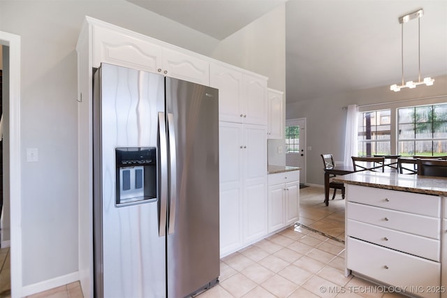 kitchen with stone countertops, white cabinetry, stainless steel fridge with ice dispenser, and light tile patterned floors