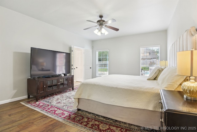 bedroom with baseboards, a ceiling fan, and wood finished floors