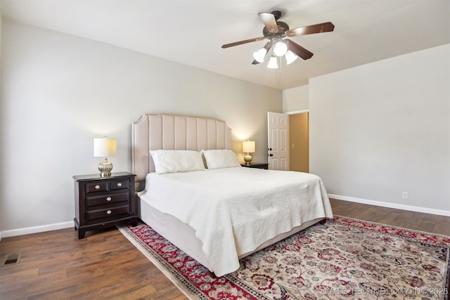 bedroom featuring baseboards, ceiling fan, visible vents, and wood finished floors