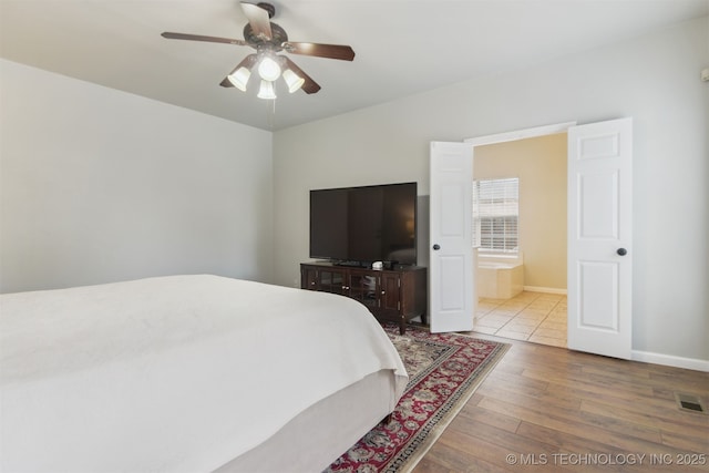 bedroom with wood-type flooring, baseboards, a ceiling fan, and visible vents