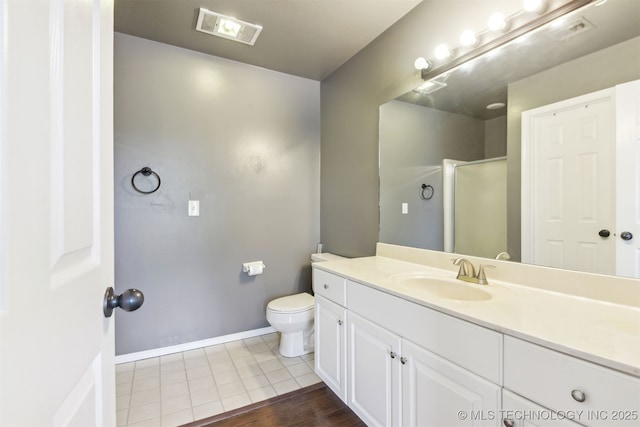 bathroom featuring toilet, a shower with shower door, visible vents, baseboards, and vanity