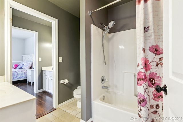 full bathroom with toilet, shower / tub combo with curtain, baseboards, tile patterned flooring, and vanity