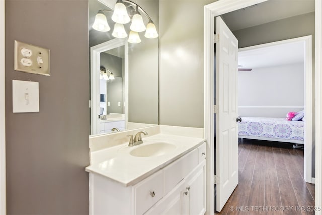 bathroom with an inviting chandelier, wood finished floors, and vanity