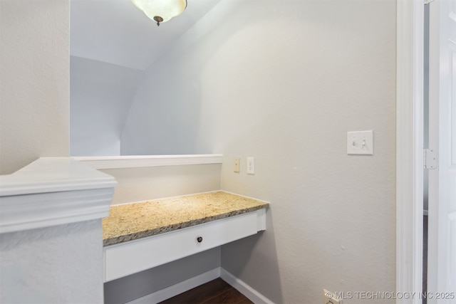 interior details featuring built in study area, wood finished floors, and baseboards