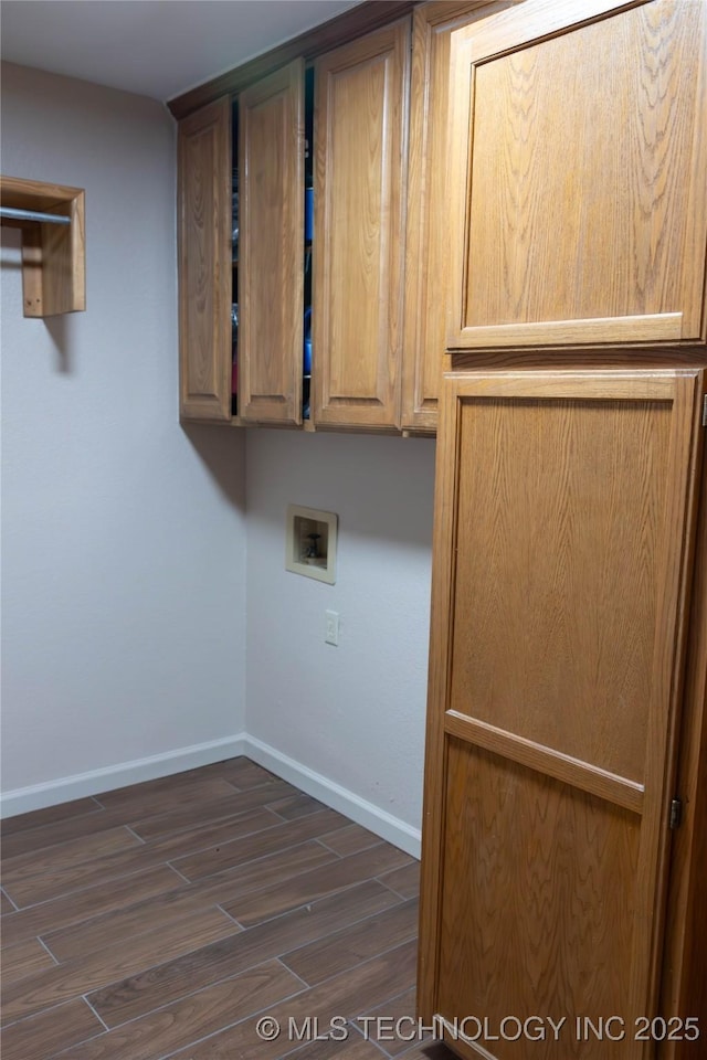 laundry area featuring cabinet space, dark wood finished floors, baseboards, and hookup for a washing machine
