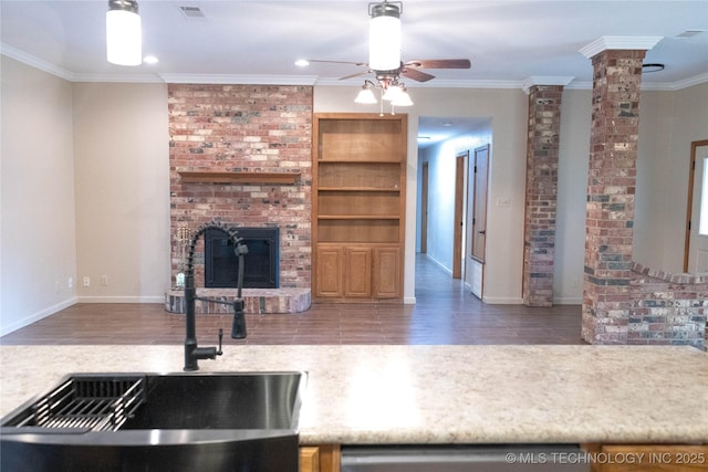 unfurnished living room featuring a sink, ornate columns, visible vents, a fireplace, and ceiling fan