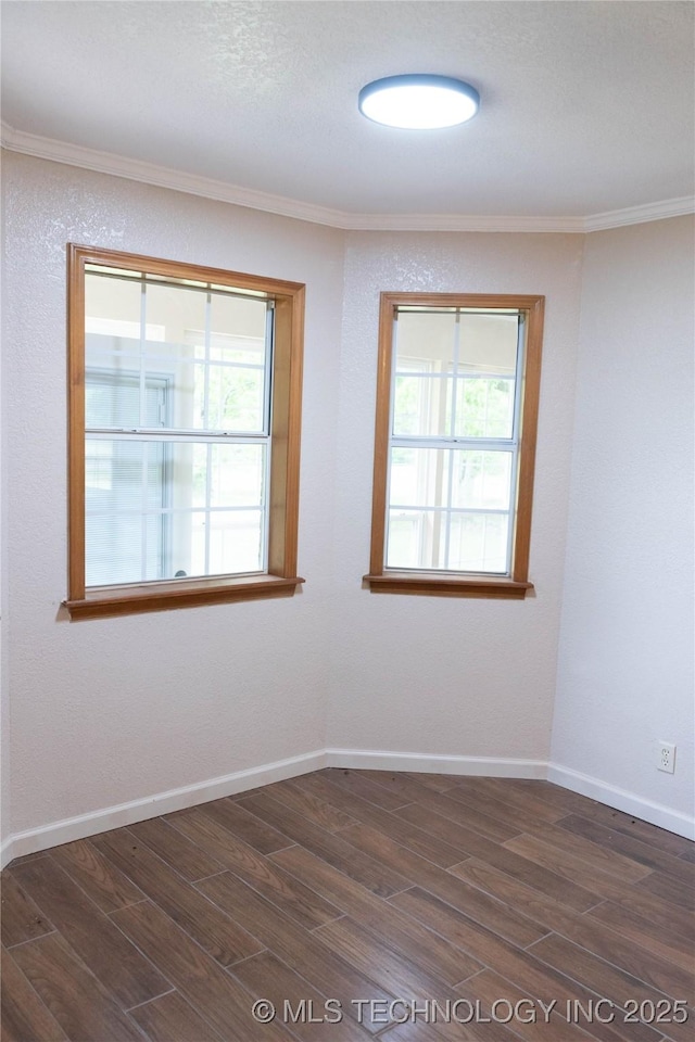unfurnished room featuring baseboards, crown molding, and dark wood-type flooring