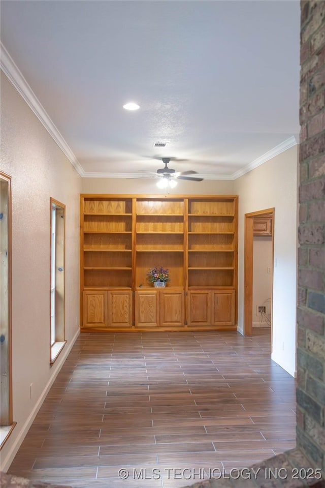 interior space with visible vents, dark wood finished floors, crown molding, a ceiling fan, and baseboards