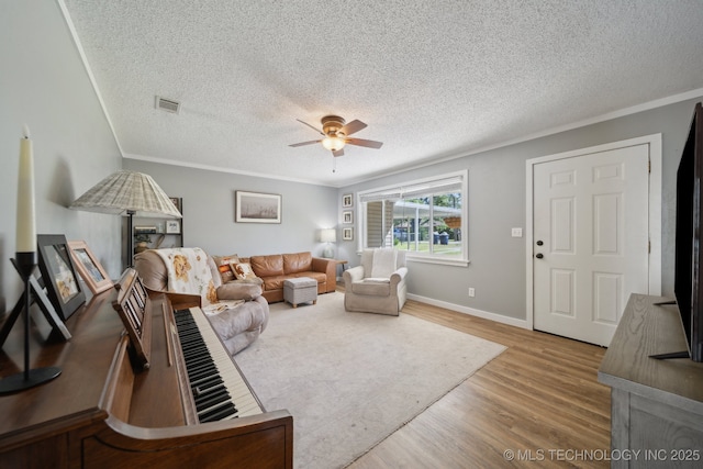 141 S Bryan St, Copan, OK 74022 - living area with a ceiling fan, a textured ceiling, baseboards, visible vents, and wood finished floors