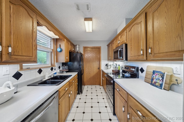 141 S Bryan St, Copan, OK 74022 - kitchen featuring a sink, stainless steel appliances, light floors, visible vents, and tasteful backsplash