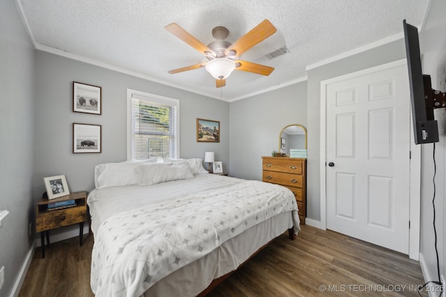 141 S Bryan St, Copan, OK 74022 - bedroom with crown molding, a textured ceiling, visible vents, dark wood-style flooring, and baseboards