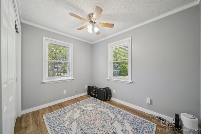 141 S Bryan St, Copan, OK 74022 - bedroom featuring multiple windows, ornamental molding, a textured ceiling, and wood finished floors