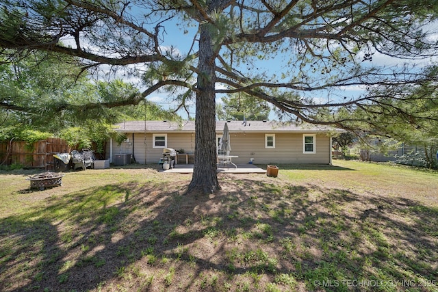 141 S Bryan St, Copan, OK 74022 - rear view of house with a fire pit, fence, central air condition unit, a yard, and a patio area
