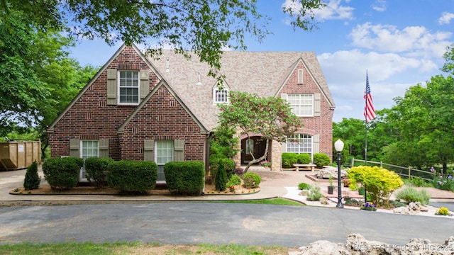 tudor home featuring brick siding