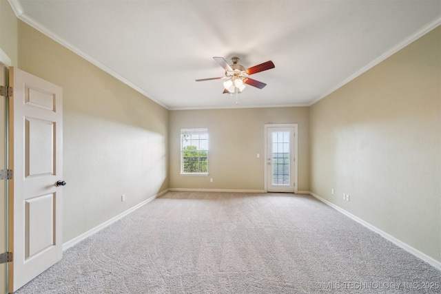 carpeted empty room with crown molding, baseboards, and a ceiling fan