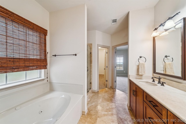 bathroom featuring a tub with jets, vanity, visible vents, a shower stall, and baseboards