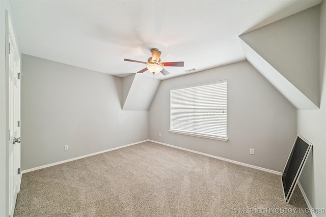 additional living space featuring vaulted ceiling, carpet, visible vents, and a ceiling fan