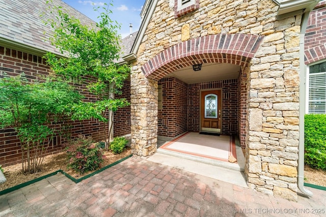 entrance to property with stone siding and brick siding