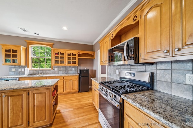 kitchen featuring ornamental molding, stainless steel appliances, open shelves, and a sink