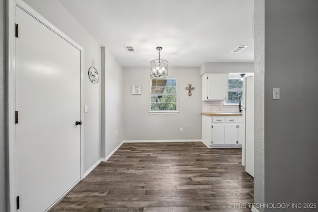 9553 W 71st St S, Tulsa, OK 74131 - unfurnished dining area with baseboards, dark wood finished floors, a chandelier, and visible vents