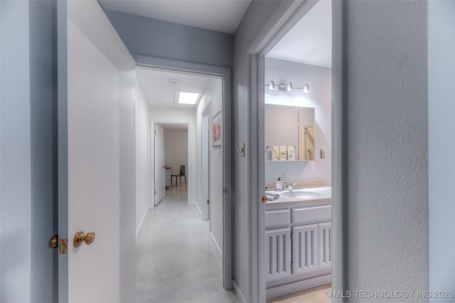 hall featuring finished concrete flooring and a sink