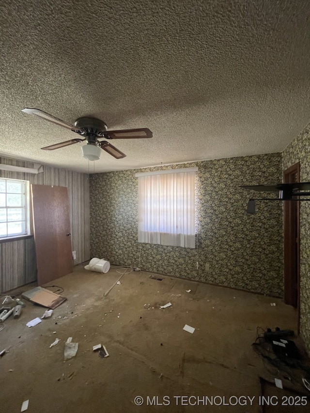 spare room with a textured ceiling and ceiling fan