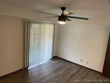 empty room featuring dark wood-style floors, baseboards, and a ceiling fan