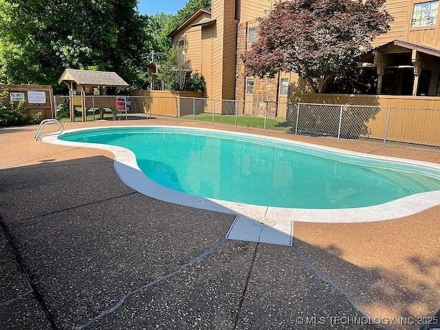 view of swimming pool featuring fence, a patio, and a fenced in pool