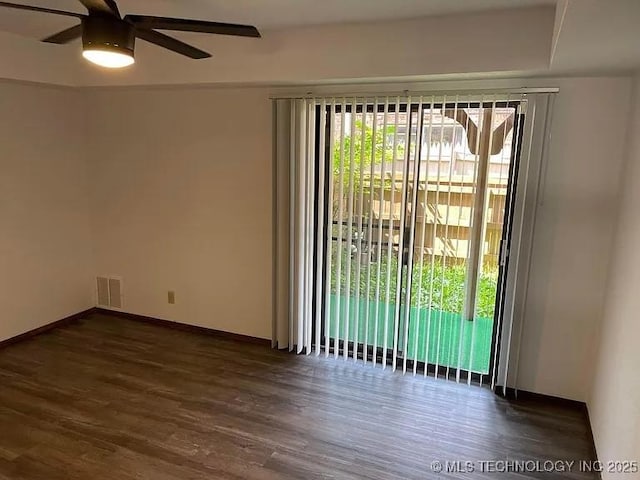 spare room featuring baseboards, a ceiling fan, visible vents, and wood finished floors