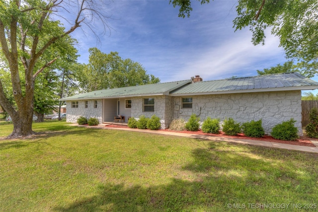 ranch-style house with metal roof, a front lawn, a chimney, and stone siding