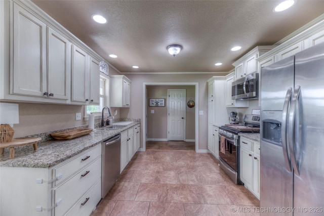 kitchen with a sink, stainless steel appliances, baseboards, and recessed lighting