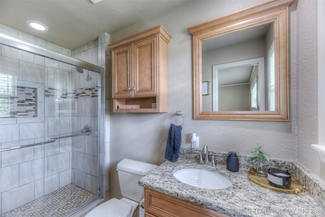 full bath featuring a stall shower, toilet, and vanity