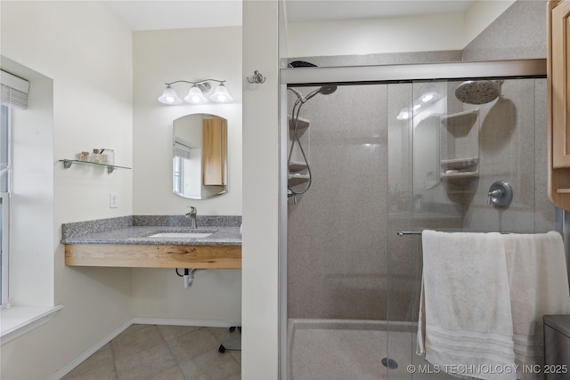 16550 S Elwood Ave, Glenpool, OK 74033 - bathroom featuring baseboards, tile patterned flooring, a shower stall, and a sink