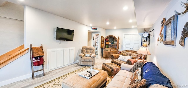 living room featuring light wood-style flooring, baseboards, and recessed lighting