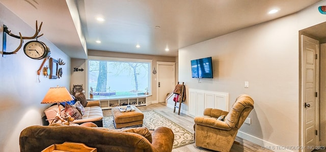 living area featuring light wood-style floors, baseboards, and recessed lighting