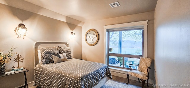 bedroom featuring baseboards, visible vents, and wood finished floors