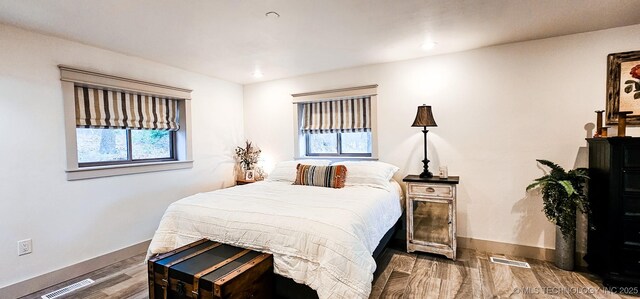 bedroom with visible vents, wood finished floors, baseboards, and recessed lighting