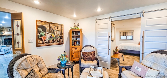 living area with a barn door, light wood-style flooring, and recessed lighting