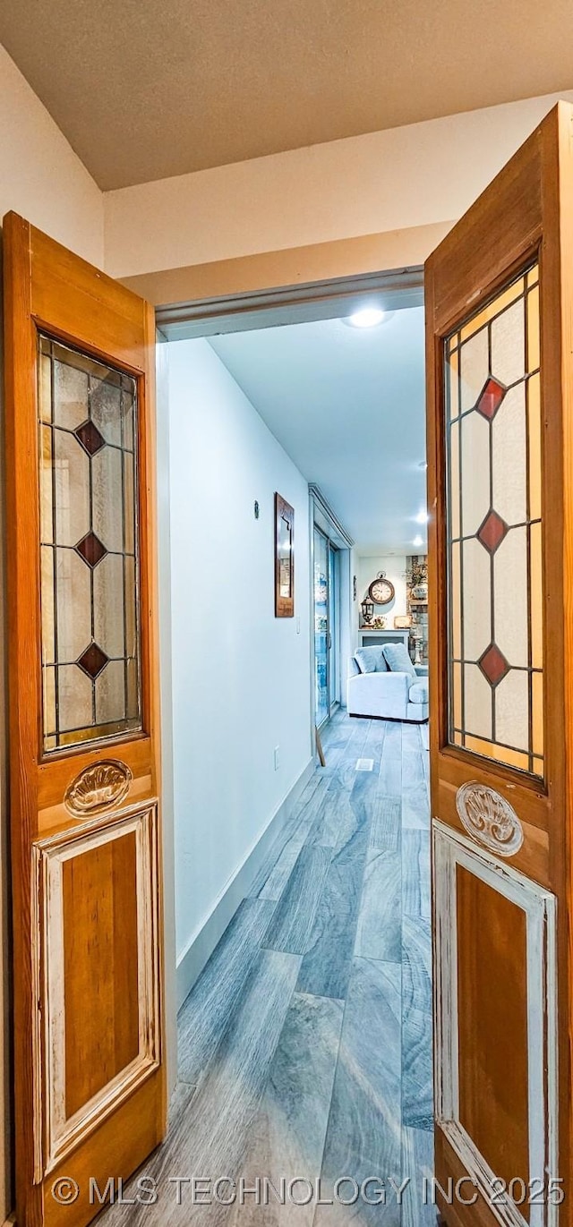 corridor with wood finished floors and baseboards