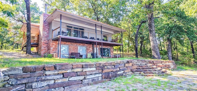 back of property with a balcony and brick siding