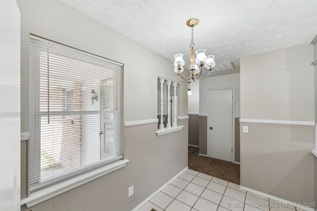 1117 W Chambers Ct, Claremore, OK 74017 - unfurnished dining area featuring light carpet, an inviting chandelier, a textured ceiling, and light tile patterned flooring