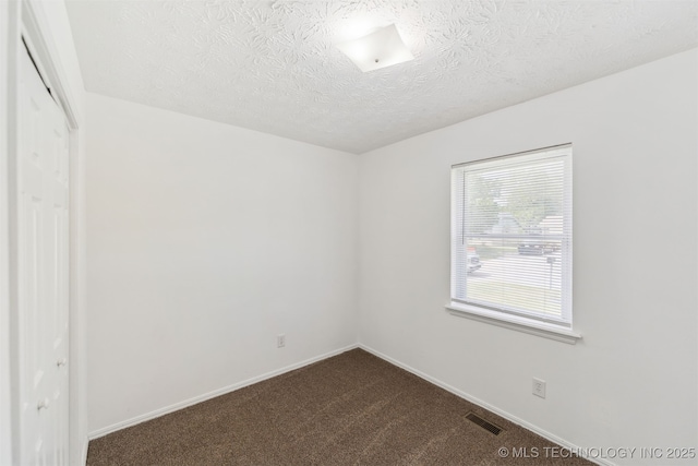 1117 W Chambers Ct, Claremore, OK 74017 - empty room featuring a textured ceiling, visible vents, baseboards, and dark colored carpet