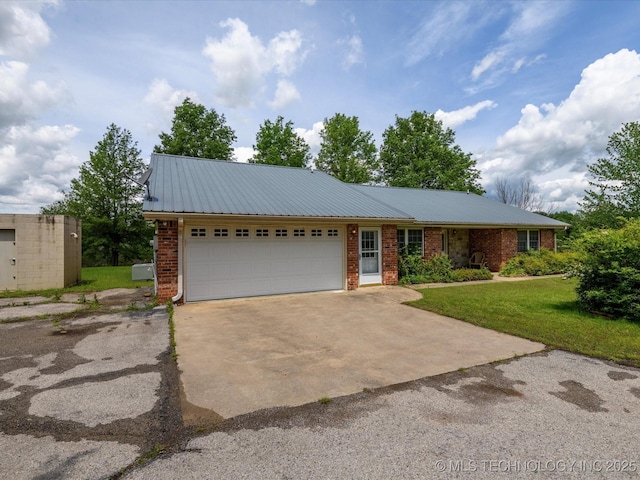 ranch-style house with an attached garage, brick siding, concrete driveway, a front yard, and metal roof