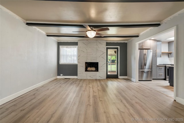 1022 W E St, Jenks, OK 74037 - unfurnished living room with beamed ceiling, light wood-type flooring, ceiling fan, baseboards, and a high end fireplace