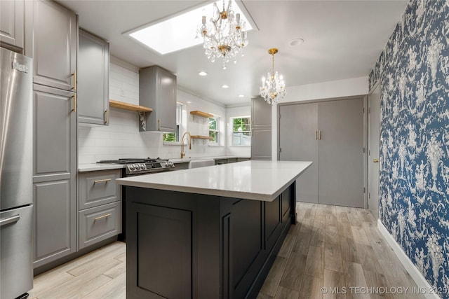1022 W E St, Jenks, OK 74037 - kitchen with freestanding refrigerator, wallpapered walls, a chandelier, gray cabinetry, and light countertops