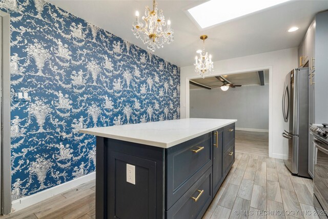 1022 W E St, Jenks, OK 74037 - kitchen with appliances with stainless steel finishes, a chandelier, baseboards, light wood-type flooring, and wallpapered walls