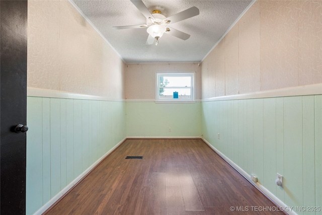 1022 W E St, Jenks, OK 74037 - empty room with wood finished floors, a textured ceiling, a wainscoted wall, a ceiling fan, and ornamental molding
