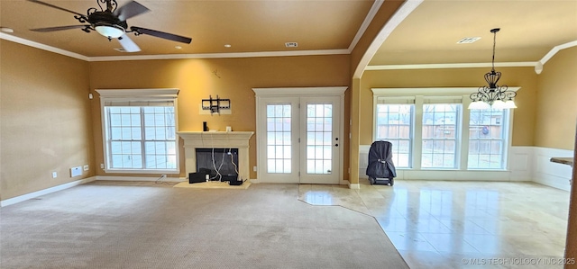 2501 Forest Ridge Parkway, Claremore, OK 74017 - unfurnished living room with crown molding, healthy amount of natural light, a glass covered fireplace, a ceiling fan, and a chandelier