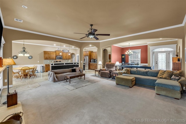 2501 Forest Ridge Parkway, Claremore, OK 74017 - living room featuring a chandelier, arched walkways, crown molding, a ceiling fan, and light colored carpet