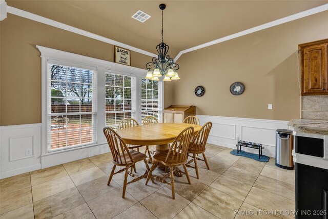 2501 Forest Ridge Parkway, Claremore, OK 74017 - dining area with a wainscoted wall, crown molding, a chandelier, a decorative wall, and light tile patterned flooring